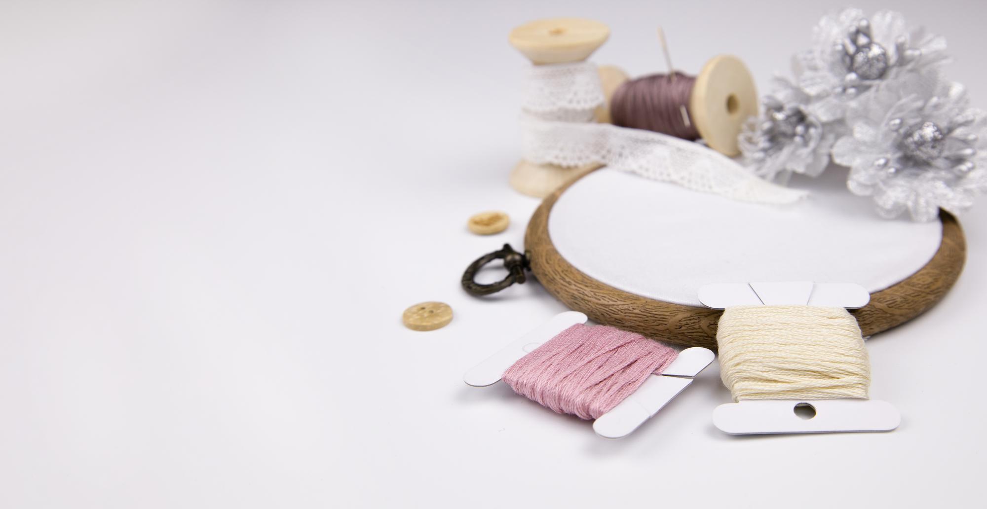 Atelierarbeitsplatz mit Stickrahmen und Fäden